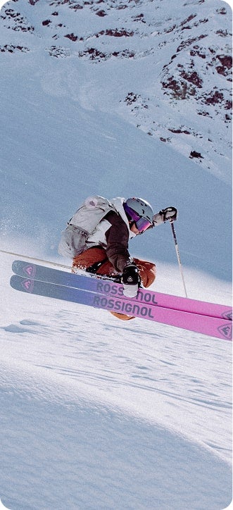 Ein Freeride-Skifahrer, der einen Sprung macht und dabei seine Skier greift