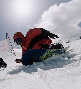 Snowboarder leaning on the board while descending, showcasing the flex of a Rossignol snowboard