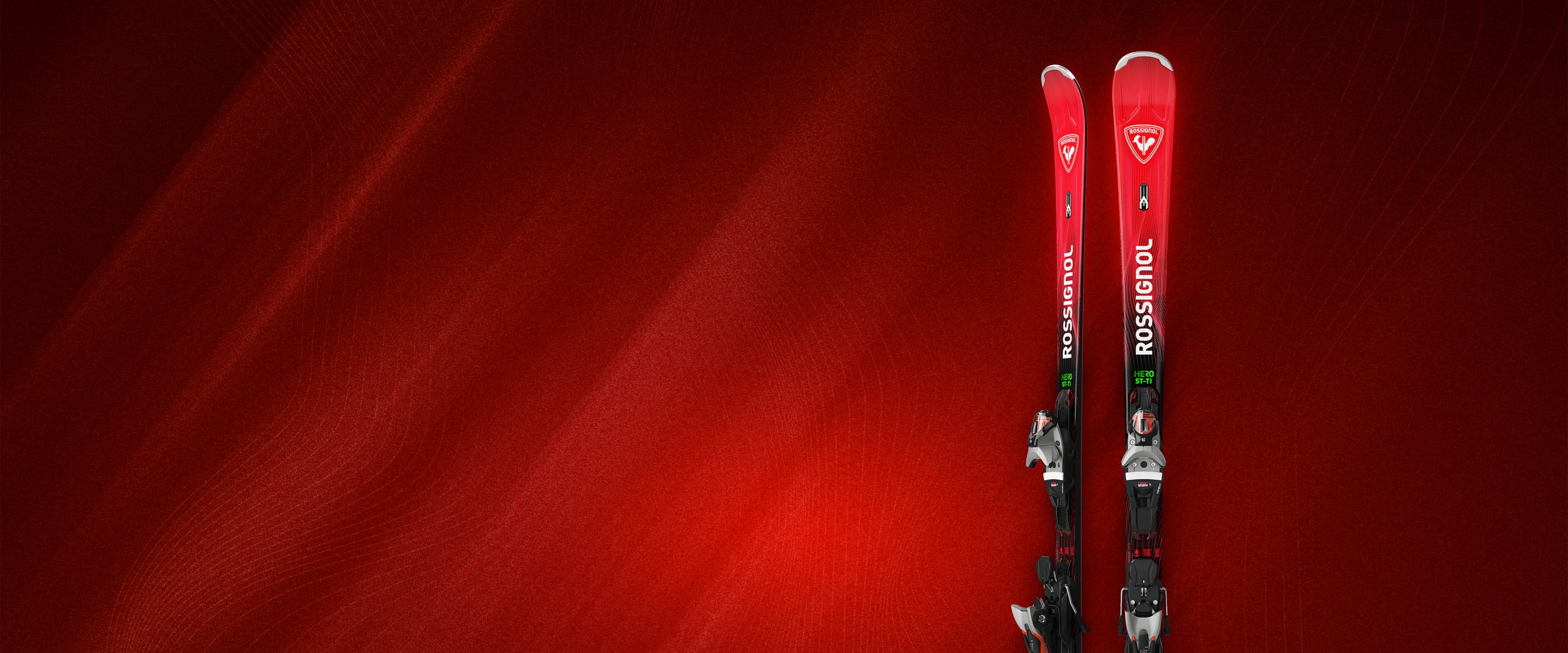 Photo entière des skis Rossignol Hero ST TI 2627 avec un fond rouge travaillé mêlant ombres et traits de couleur