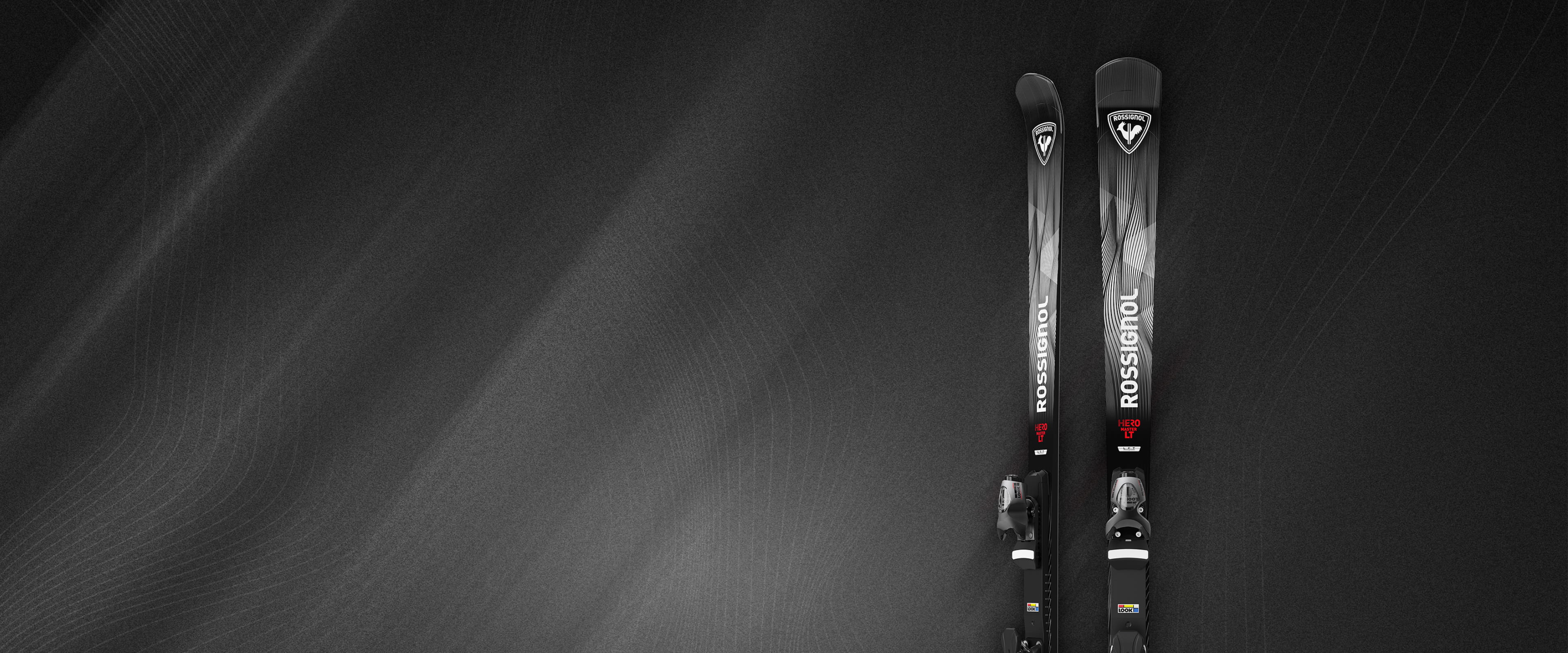 Photo des skis Rossignol Hero Master 2627 avec un fond noir et gris travaillé mêlant ombres et traits de couleur