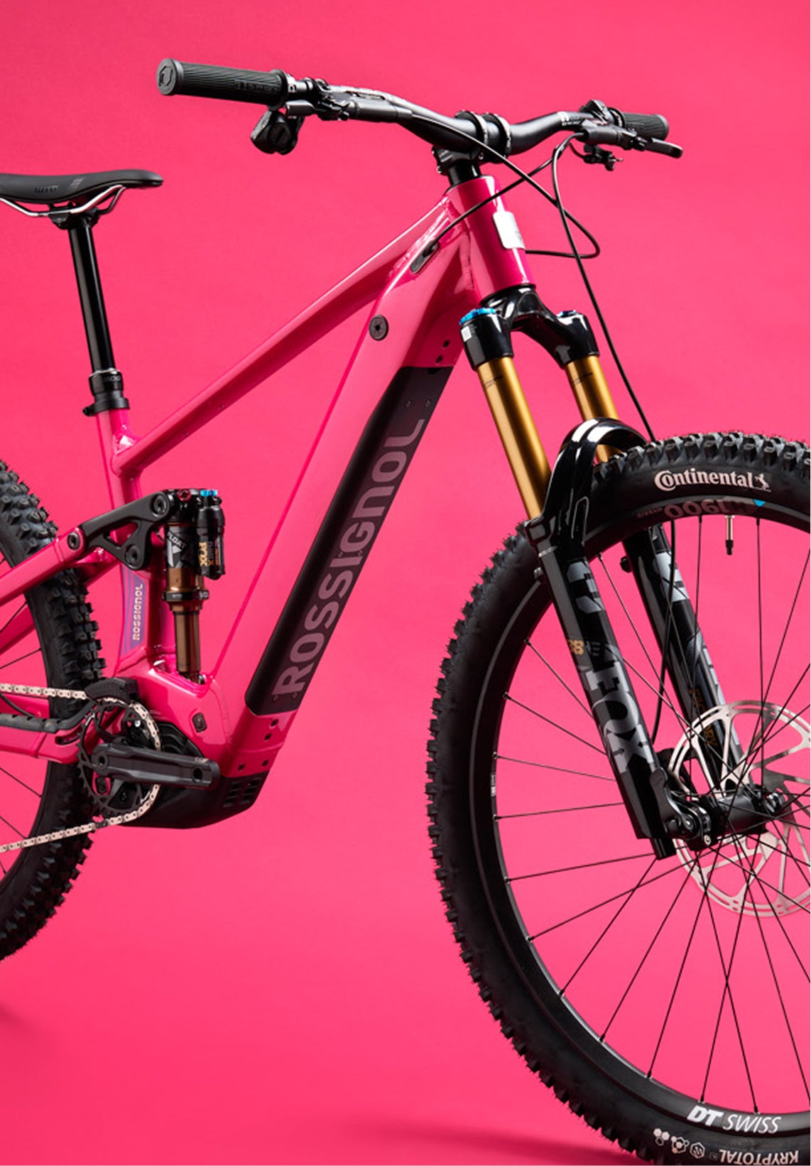 Close-up of the front section of the Rossignol After Hours electric mountain bike, showing the red frame, black suspension fork, front wheel, handlebars, and Rossignol logo on the down tube.