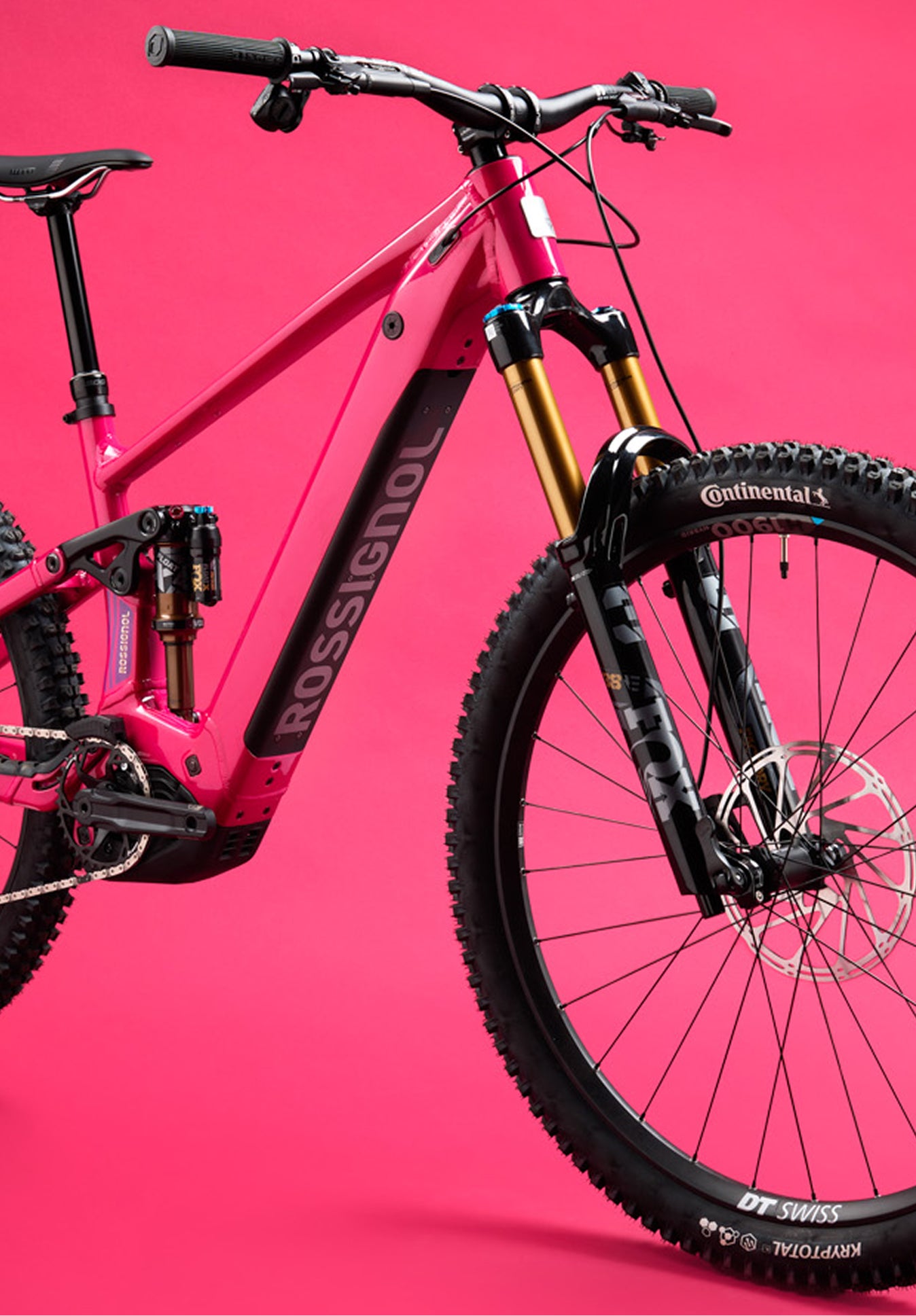 Close-up of the front section of the Rossignol After Hours electric mountain bike, showing the red frame, black suspension fork, front wheel, handlebars, and Rossignol logo on the down tube.