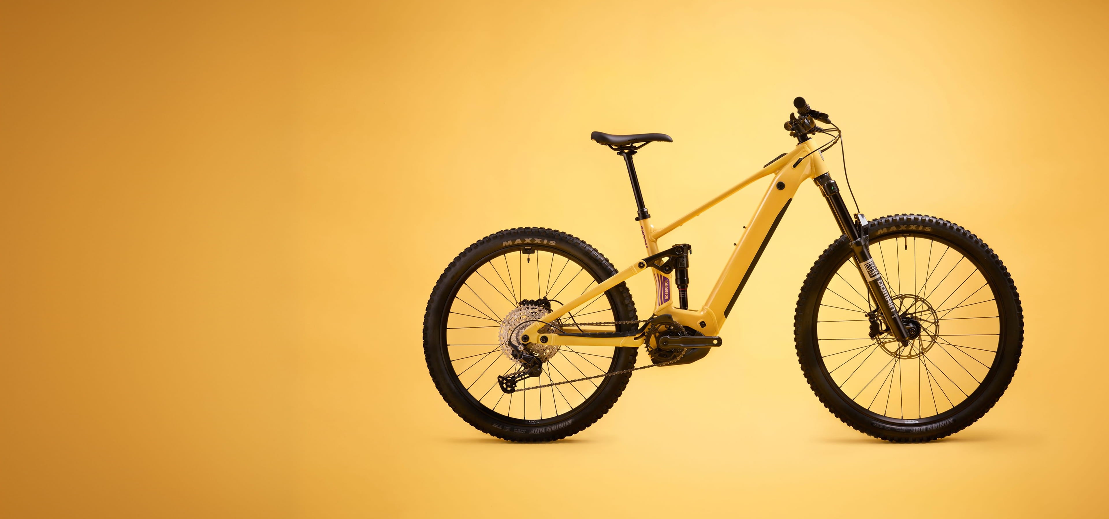 The Rossignol After Hours Deore 12 bike against a yellow background. The bike is golden-colored.