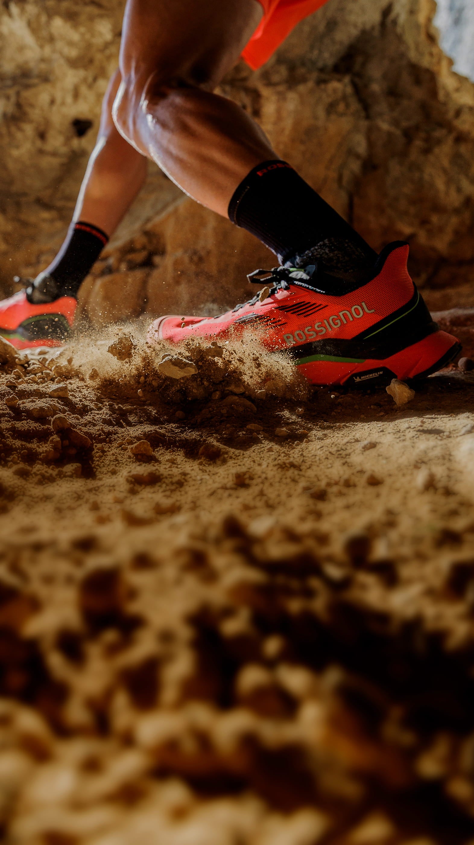 Chaussure de trail Rossignol Vezor en action sur un terrain rocheux et poussiéreux, mettant en avant son accroche, sa stabilité et sa propulsion sur les sentiers techniques.