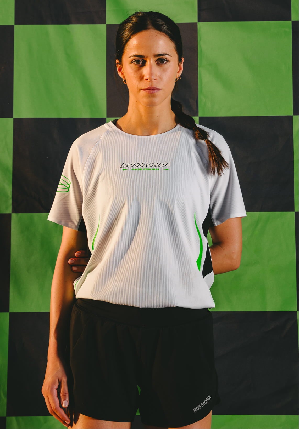 Female athlete wearing the Rossignol SAPA ULTRA TEE WOMAN SP against a black and green checkerboard background