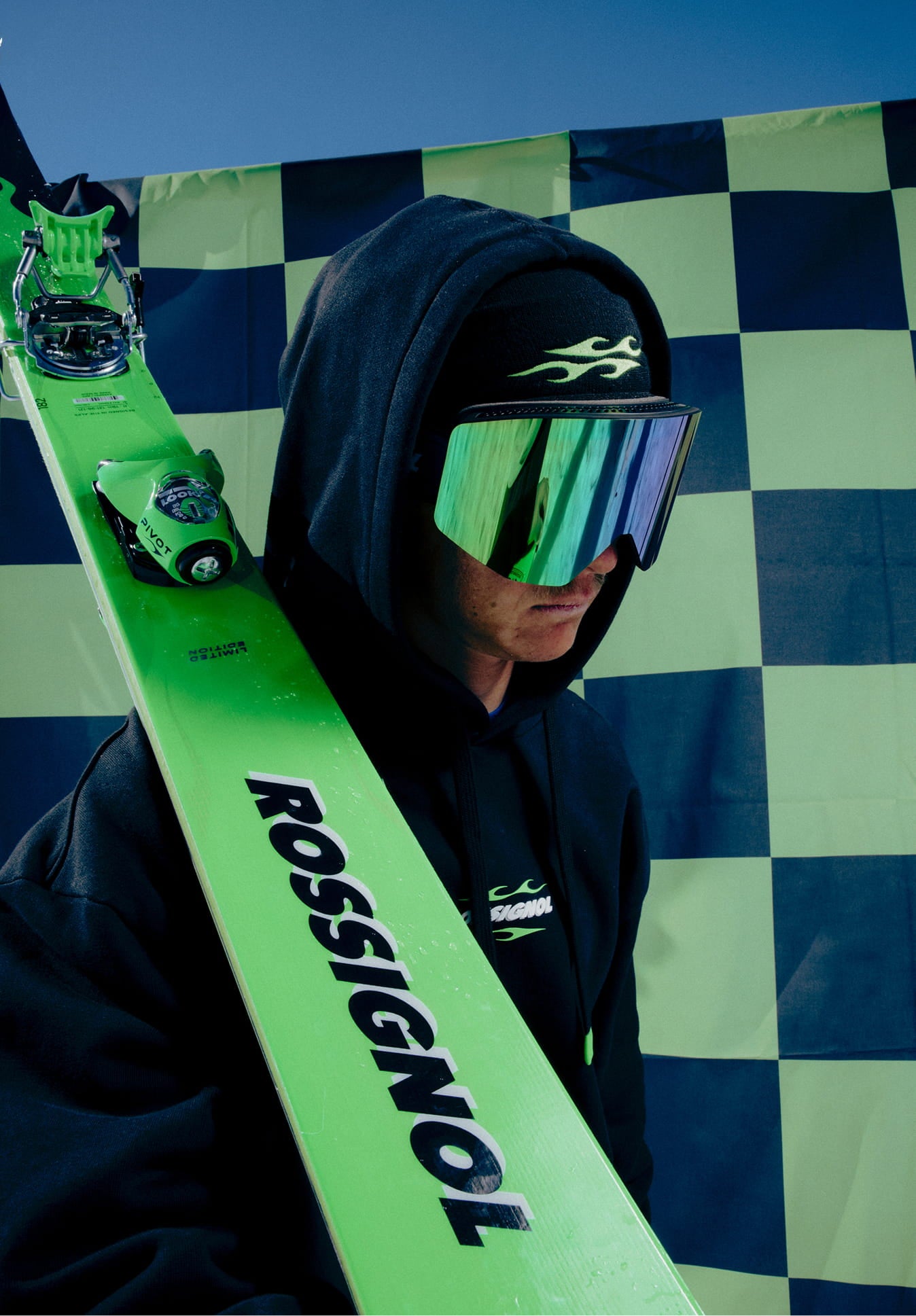 Athlète portant des skis sur les épaules avec le masque de ski OTAVA GREEN de Rossignol