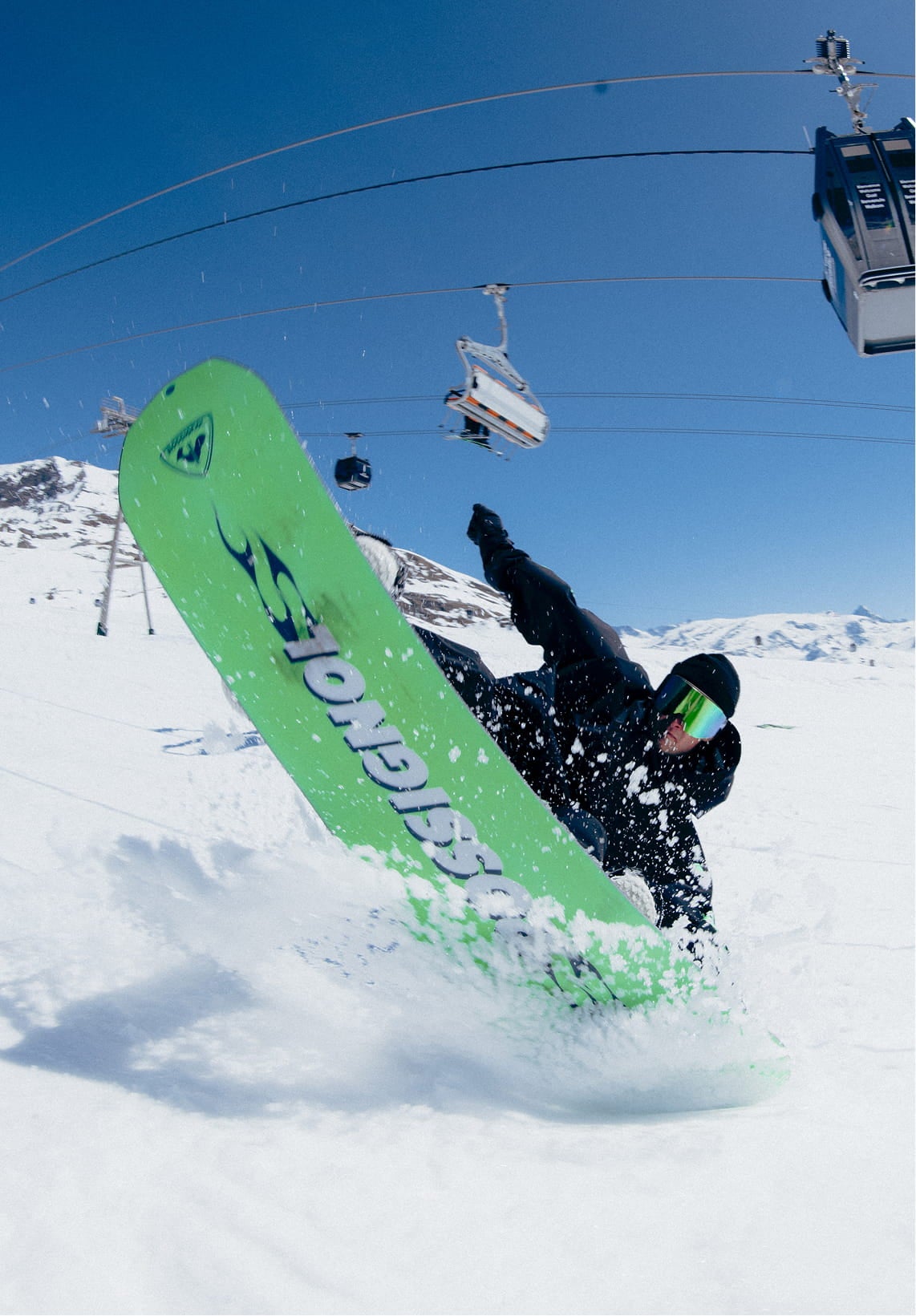 Snowboarder levant le snowboard REVENANT de Rossignol sur une surface enneigée plane pour montrer sa semelle