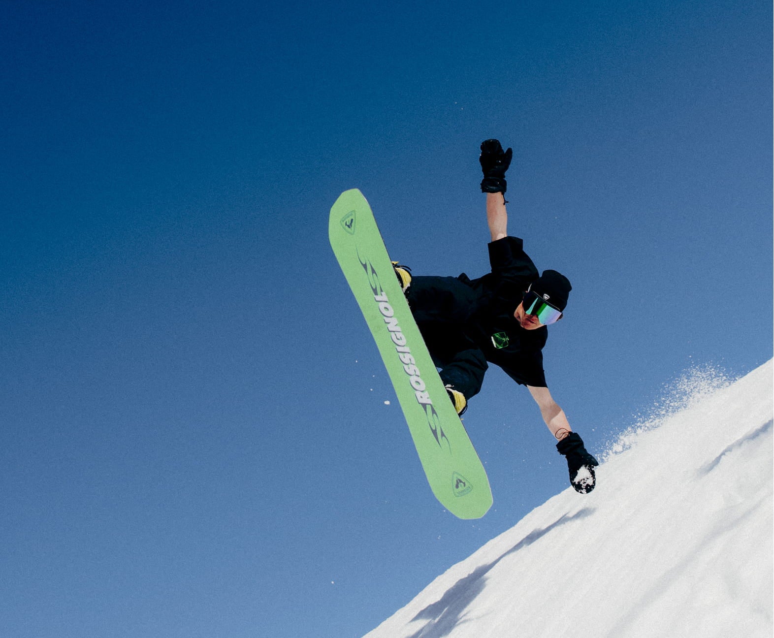 Snowboarder en action à grande vitesse avec le snowboard REVENANT de Rossignol