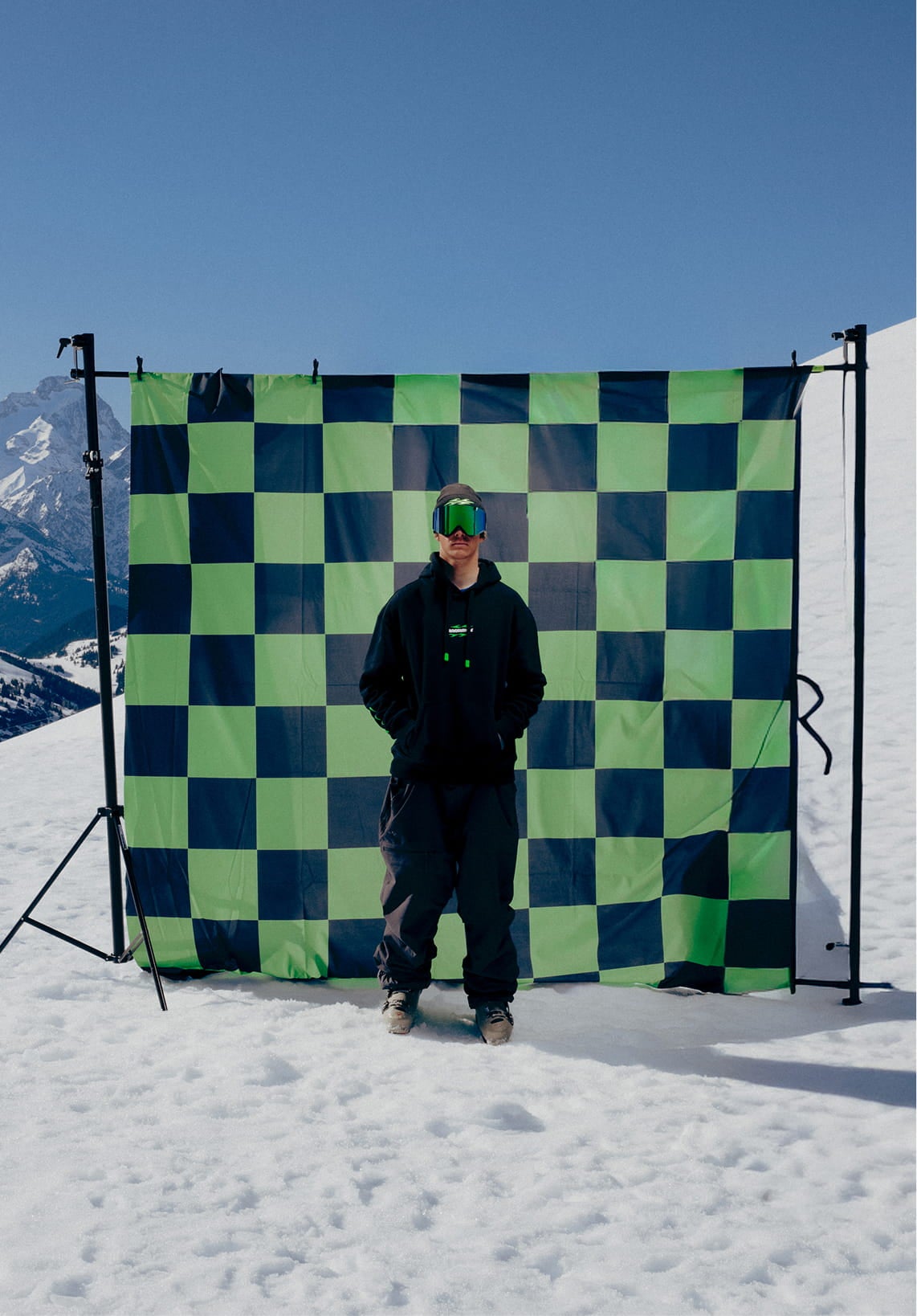 Snowboarder standing facing the camera wearing the Rossignol SUPER PROJECT HOODIE in a mountain landscape