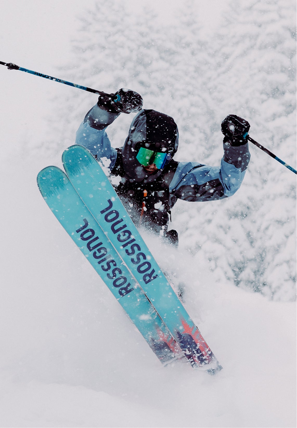 A freeride skier in deep powder, performing a jump with the tips of his Rossignol Sender skis visible.