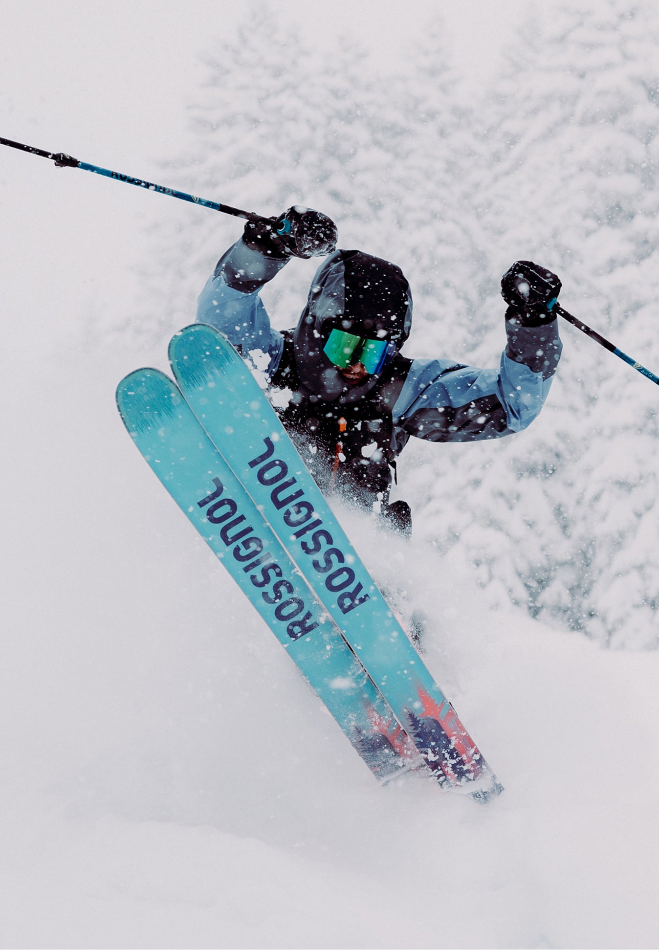 A freeride skier in deep powder, performing a jump with the tips of his Rossignol Sender skis visible.