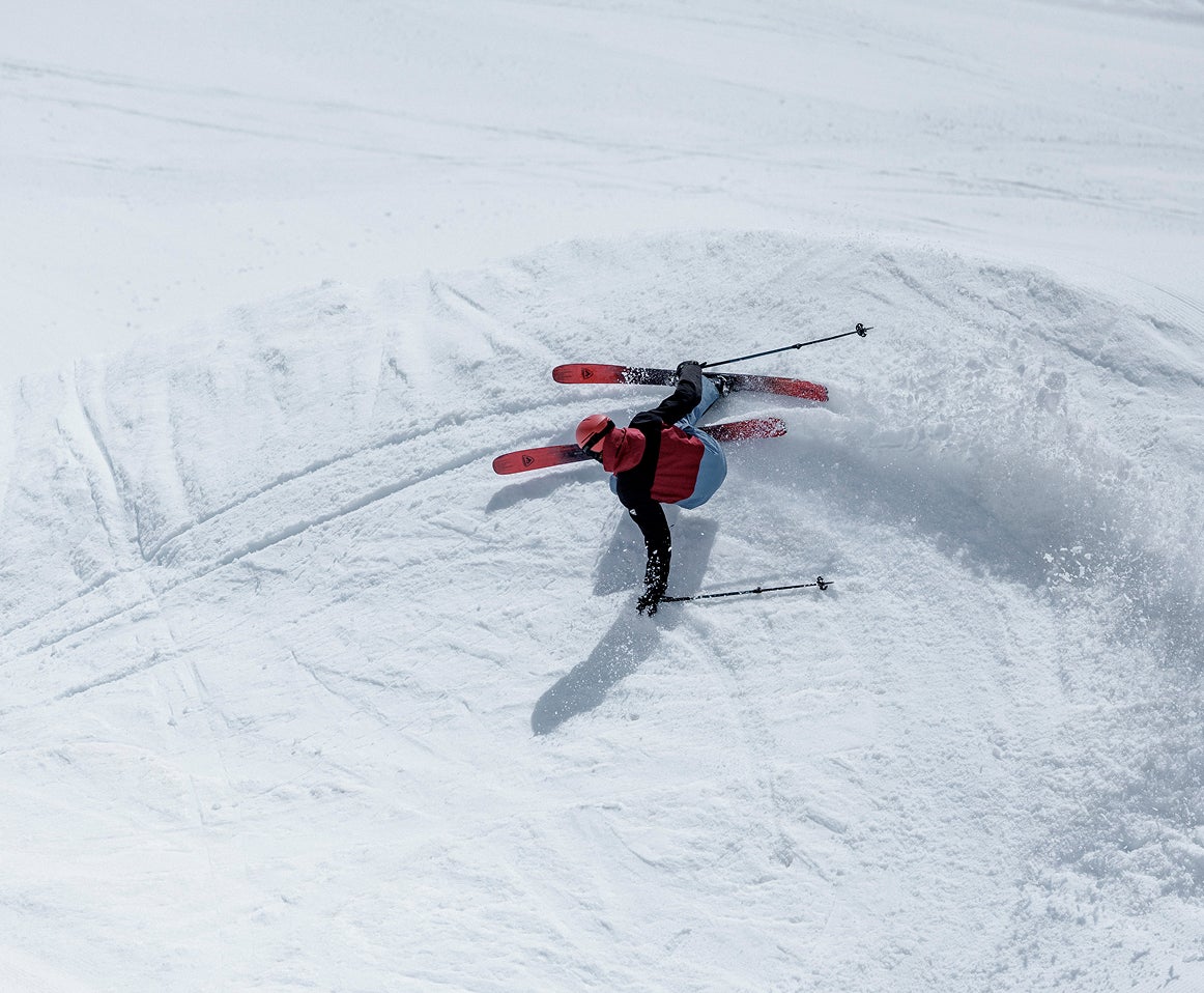 Rossignol freeride skier carving down a snowy mountain slope