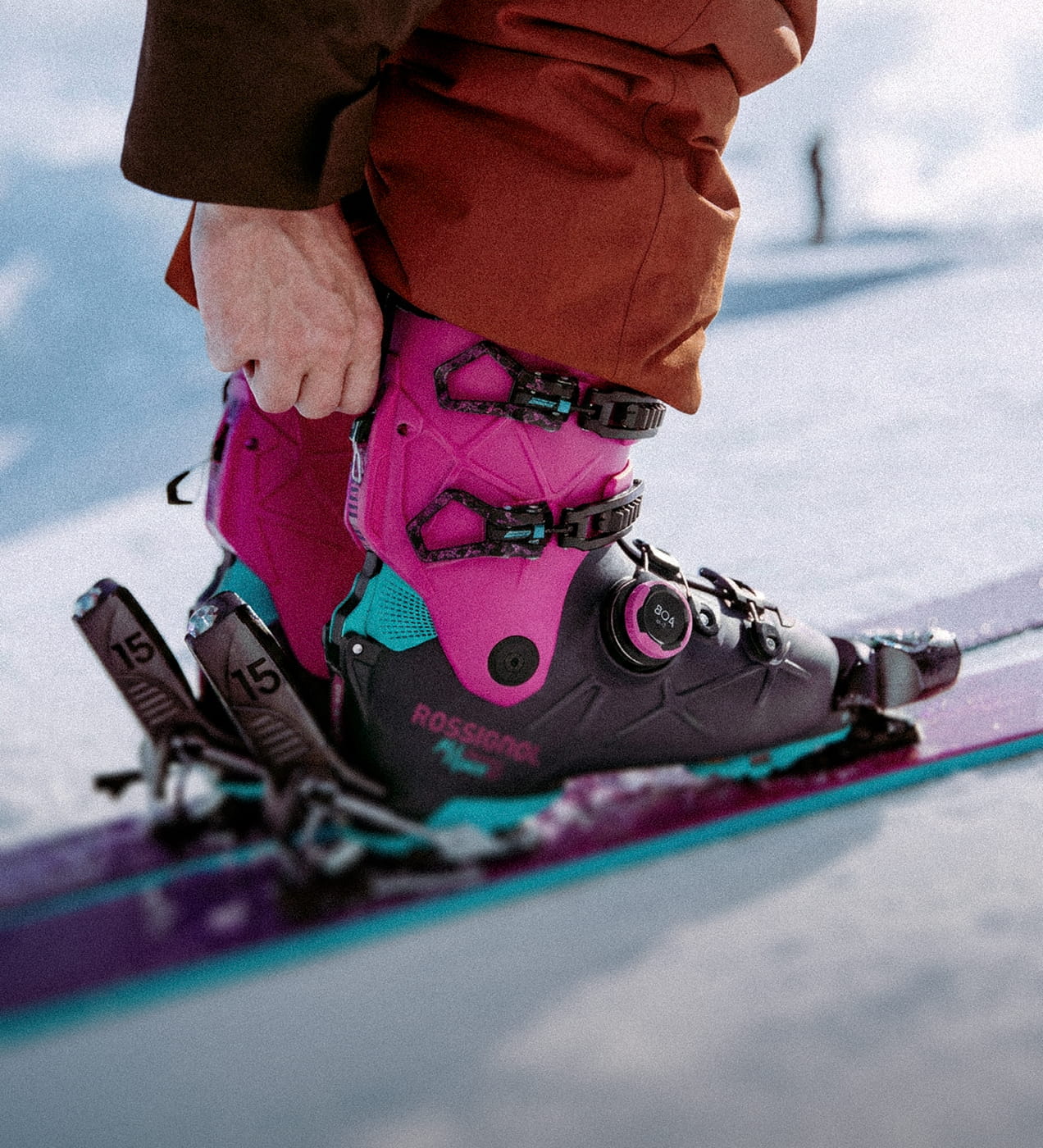 Zoom on Rossignol Alltrack 130 Elite freeride ski boots, with a person adjusting the "hike" mode mechanism.