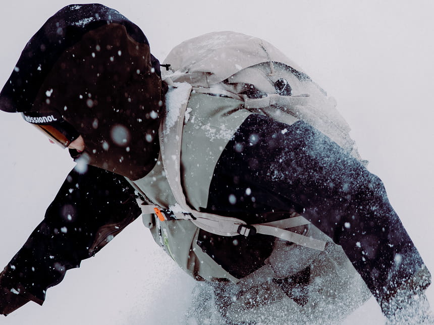 Skieur portant un sac à dos technique Rossignol en pleine progression sous la neige en montagne