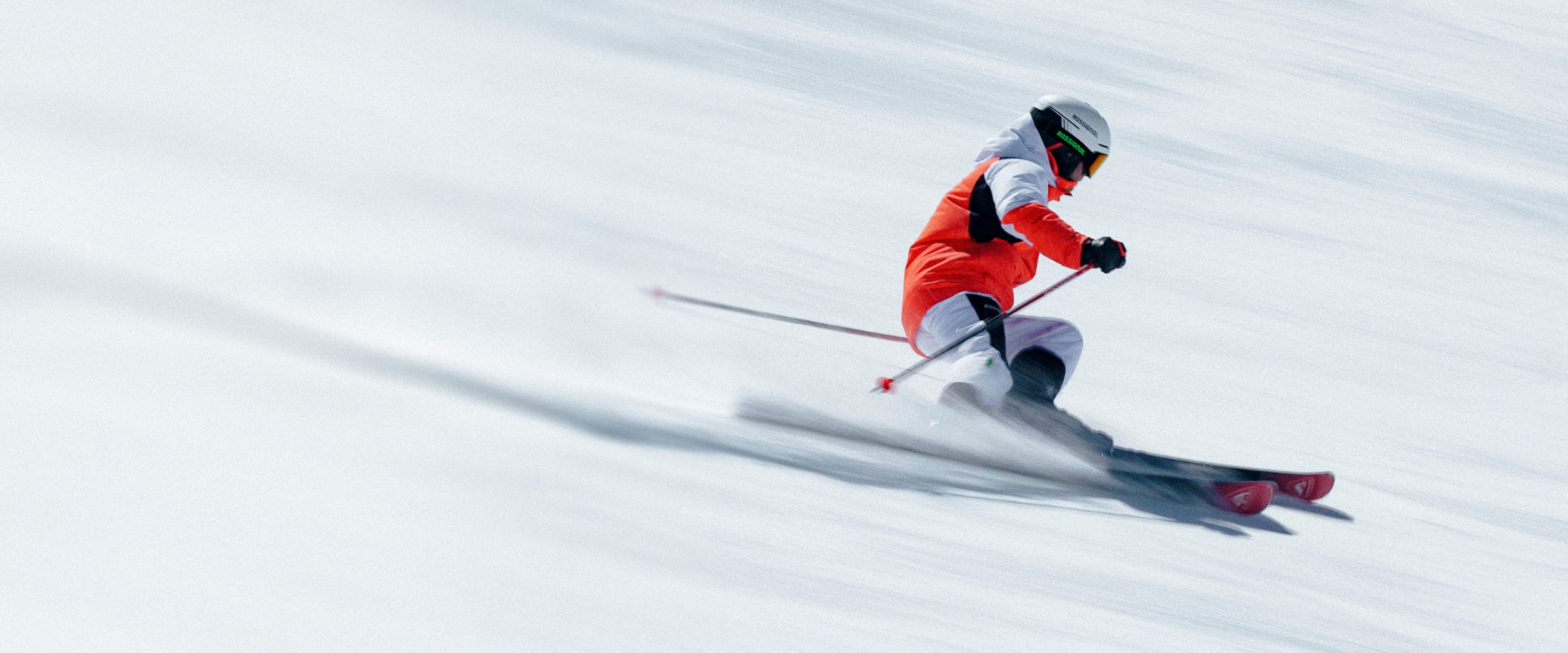 Skis alpins Rossignol Hero ST TI en action lors d’un virage dynamique sur une piste enneigée