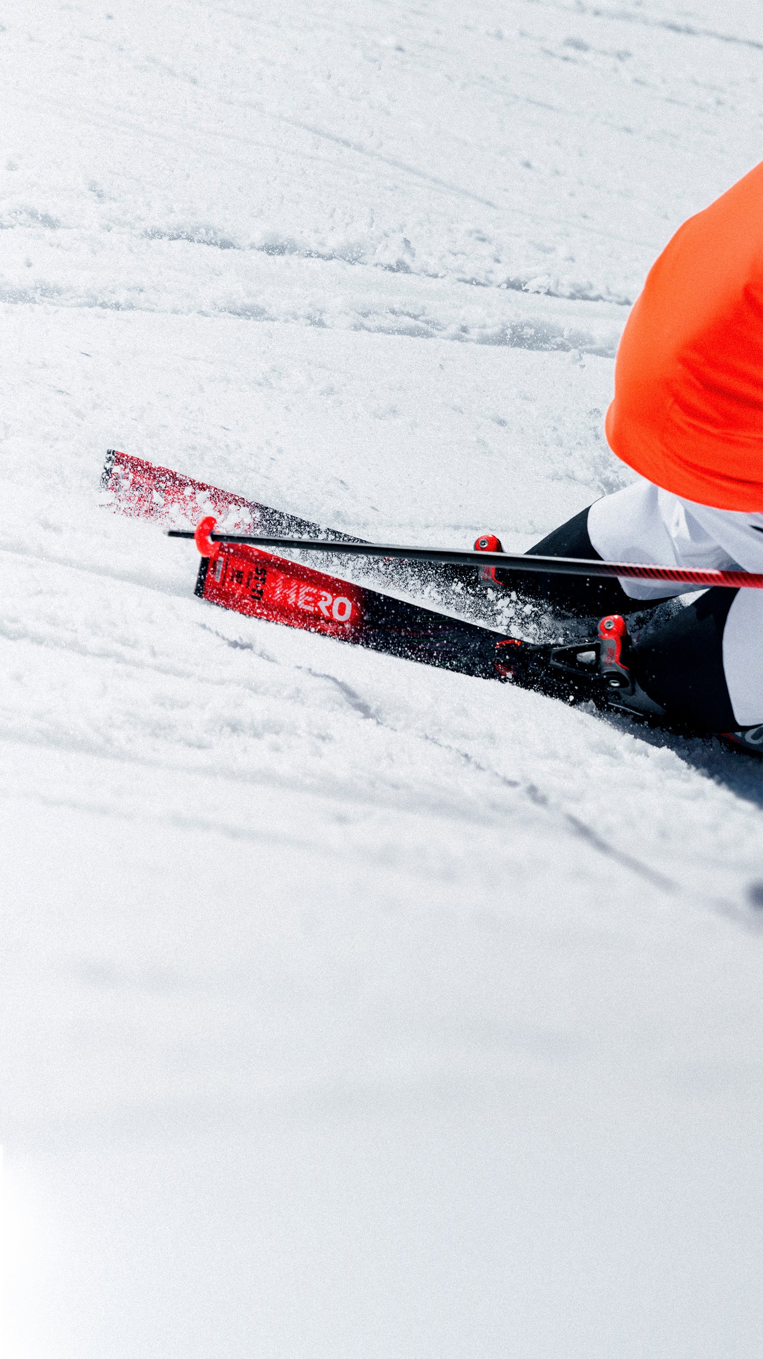 Skifahrer in einer Kurve auf präparierter Piste mit Rossignol Hero ST TI Skiern, die Schnee aufwirbeln.